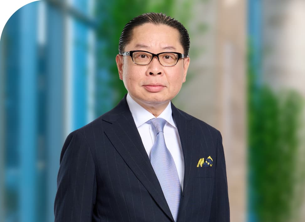 Professional man in a pinstripe suit, glasses, and light blue tie against blurred background.